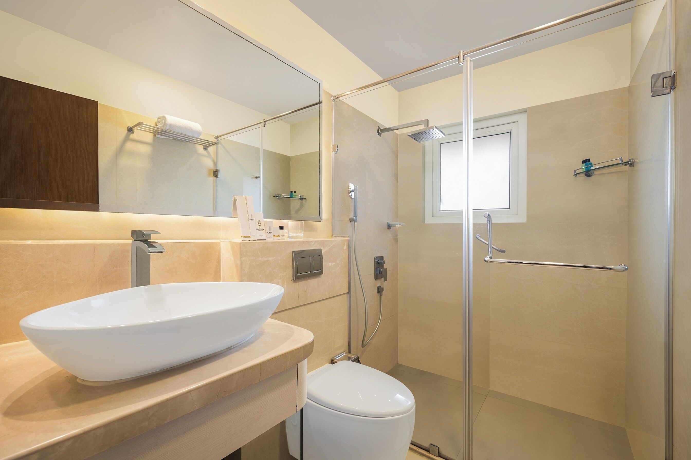 A modern bathroom with a large sink, a toilet, and a glass-enclosed shower.