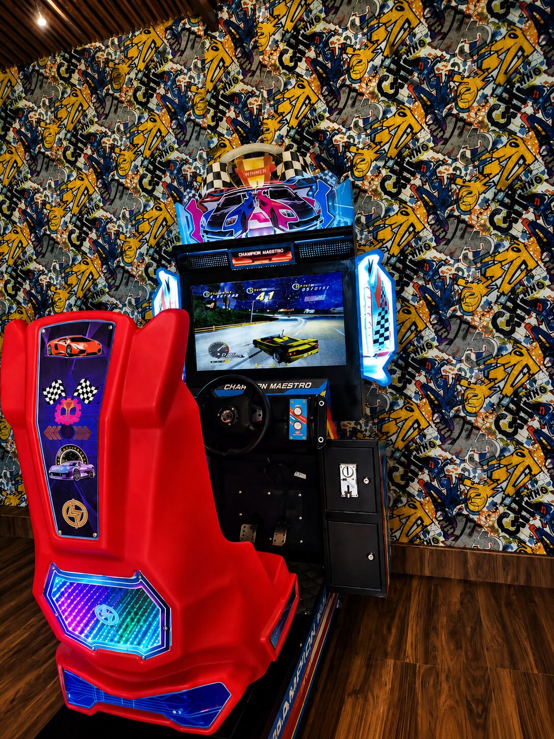 A racing game arcade with a vibrant, graffiti-covered wall in the background.