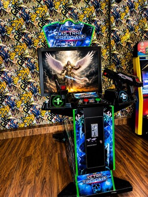 A gaming setup with a monitor, keyboard, and mouse, surrounded by a wall with graffiti. - Excel Hotels & Resorts Corbett (Ramnagar)