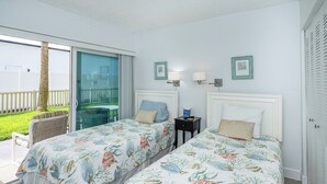 Une chambre d’hôtel avec deux lits, un balcon et une vue sur l’extérieur.