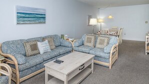Un salon comprenant un canapé, une table basse et une table à manger avec des chaises.