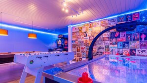 A foosball table in a room with a wall covered in vintage road signs and memorabilia.
