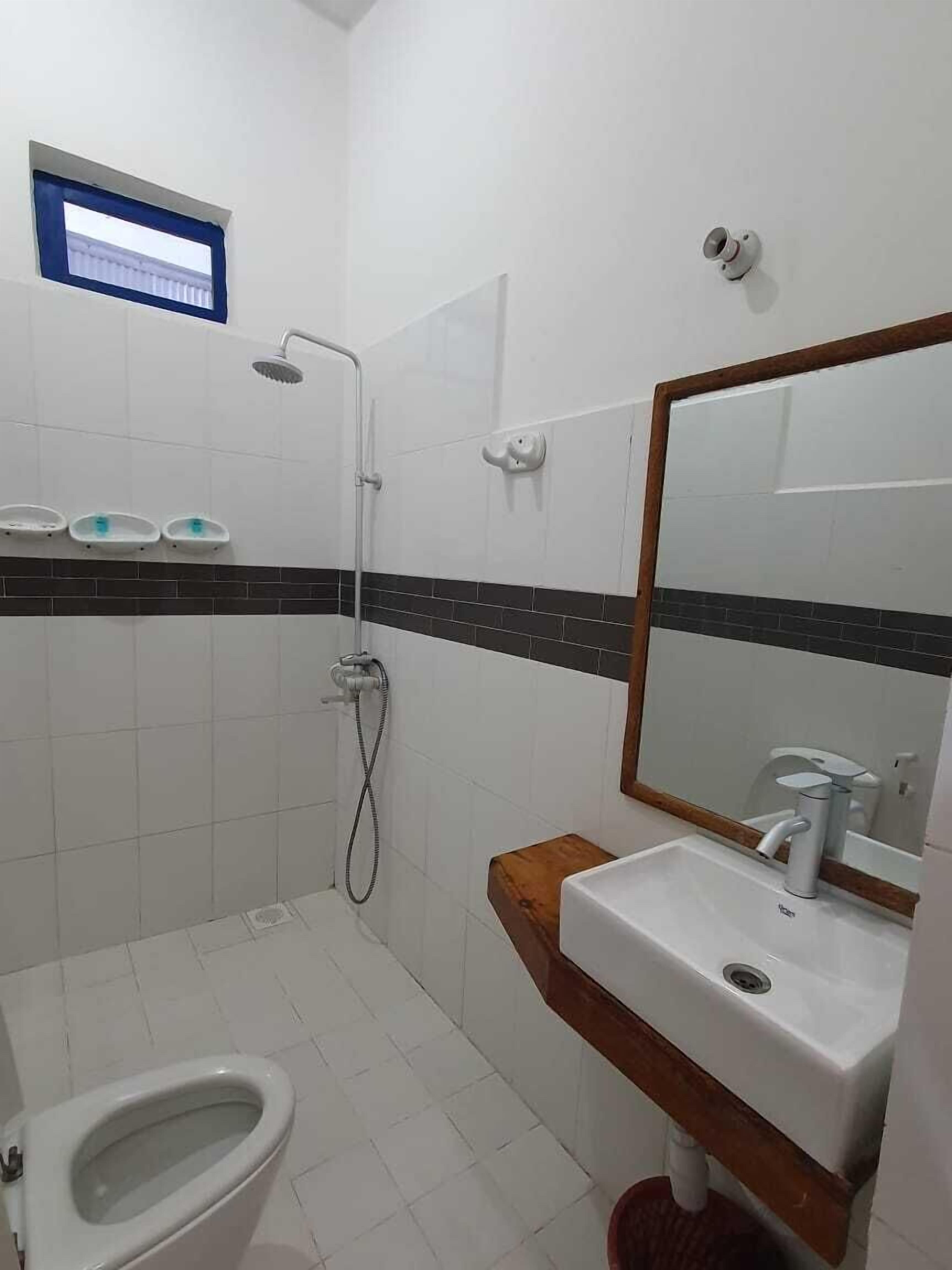 A bathroom with a shower, toilet, and sink.