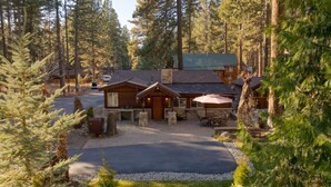 Eine Lodge mit einem zentralen Gebäude, einer überdachten Terrasse und einer Auffahrt.