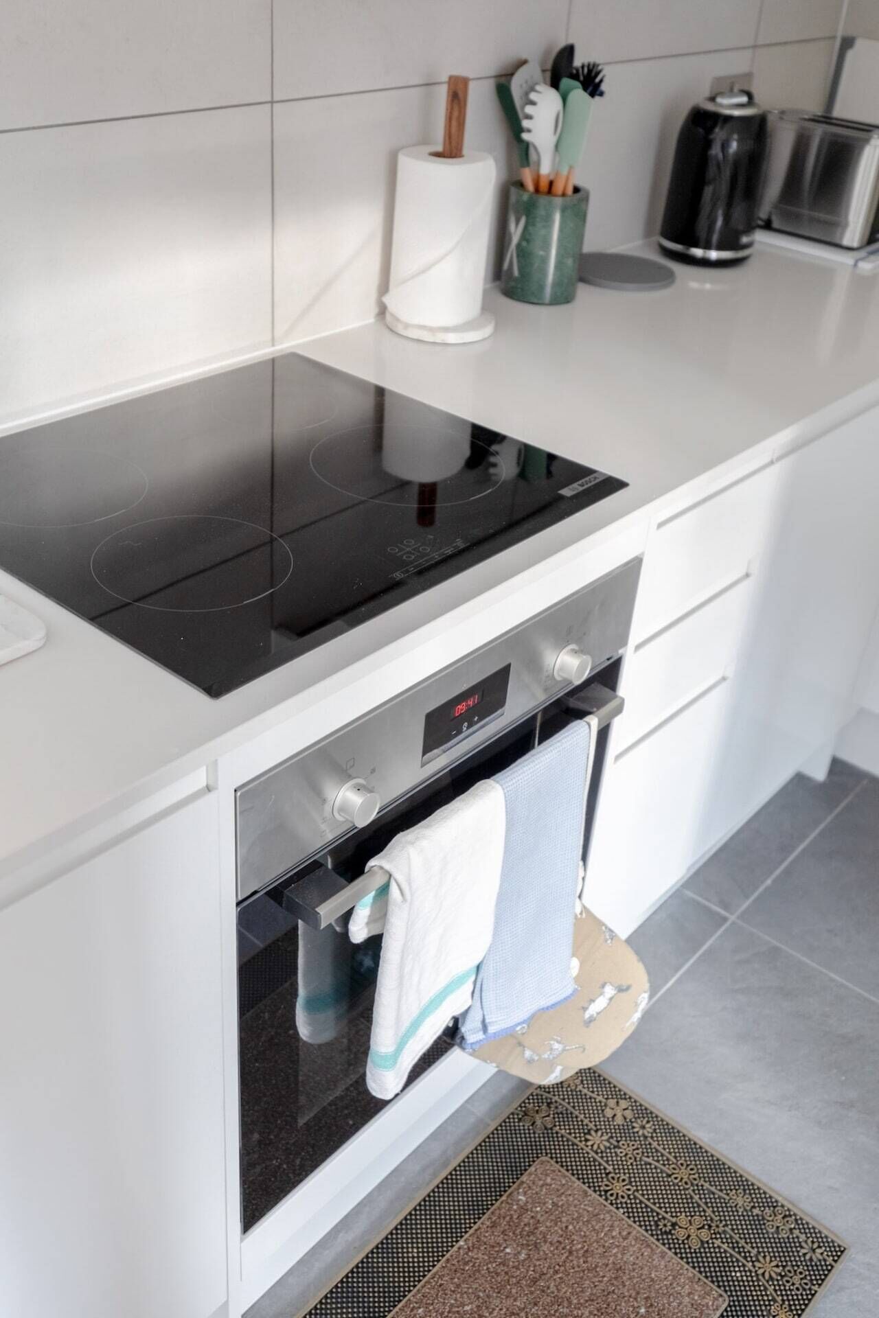 Une cuisine moderne équipée d’une cuisinière et d’un four intégrés, ainsi que d’un petit plan de travail agrémenté d’un porte-essuie-tout et d’une machine à café.
