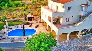 A two-story house with a swimming pool, outdoor seating, and a view of the surrounding landscape. - Villa with amazing sea view, quite area (Krusevo)