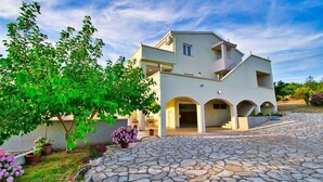 A two-story building with a stone-paved courtyard, arched entrances, and potted plants. - Villa with amazing sea view, quite area (Krusevo)