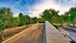 A courtyard with a croquet field, lounge chairs, and a stone pathway. - Villa with amazing sea view, quite area (Krusevo)