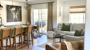 Un vaste espace de vie comprenant une table à manger, des chaises, un canapé et un fauteuil en cuir.