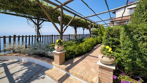 A garden with a wooden pergola, brick pathway, and potted plants. - La Casa del 600 Sea View on the Amalfi Coast, with patio and garden (Tovere (San Pietro))