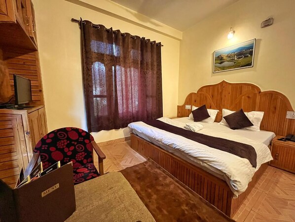 Un dormitorio ordenado con una cama de madera, un escritorio con silla y una ventana con cortinas.