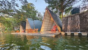 Zona tranquila de piscina exterior con una fuente de agua geométrica y mobiliario.