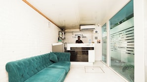 A reception area with a teal sofa, a reception desk, and a large window. - Hotel Twigo Inn (Mumbai)