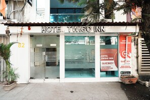 Un hotel anomenat "Hotel Twigo Inn" amb façana de vidre i el número "82" visible a la paret.