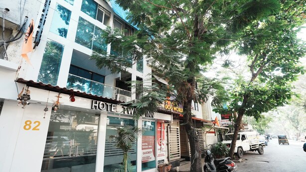 A hotel with a visible number '82' on the facade, a sign for 'Hotel Twink Inn', and a 'Glass Inn' sign. - Hotel Twigo Inn (Mumbai)