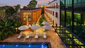 A modern hotel with a pool area, sun loungers, and umbrellas. - Protea Hotel Luanda (Luanda)