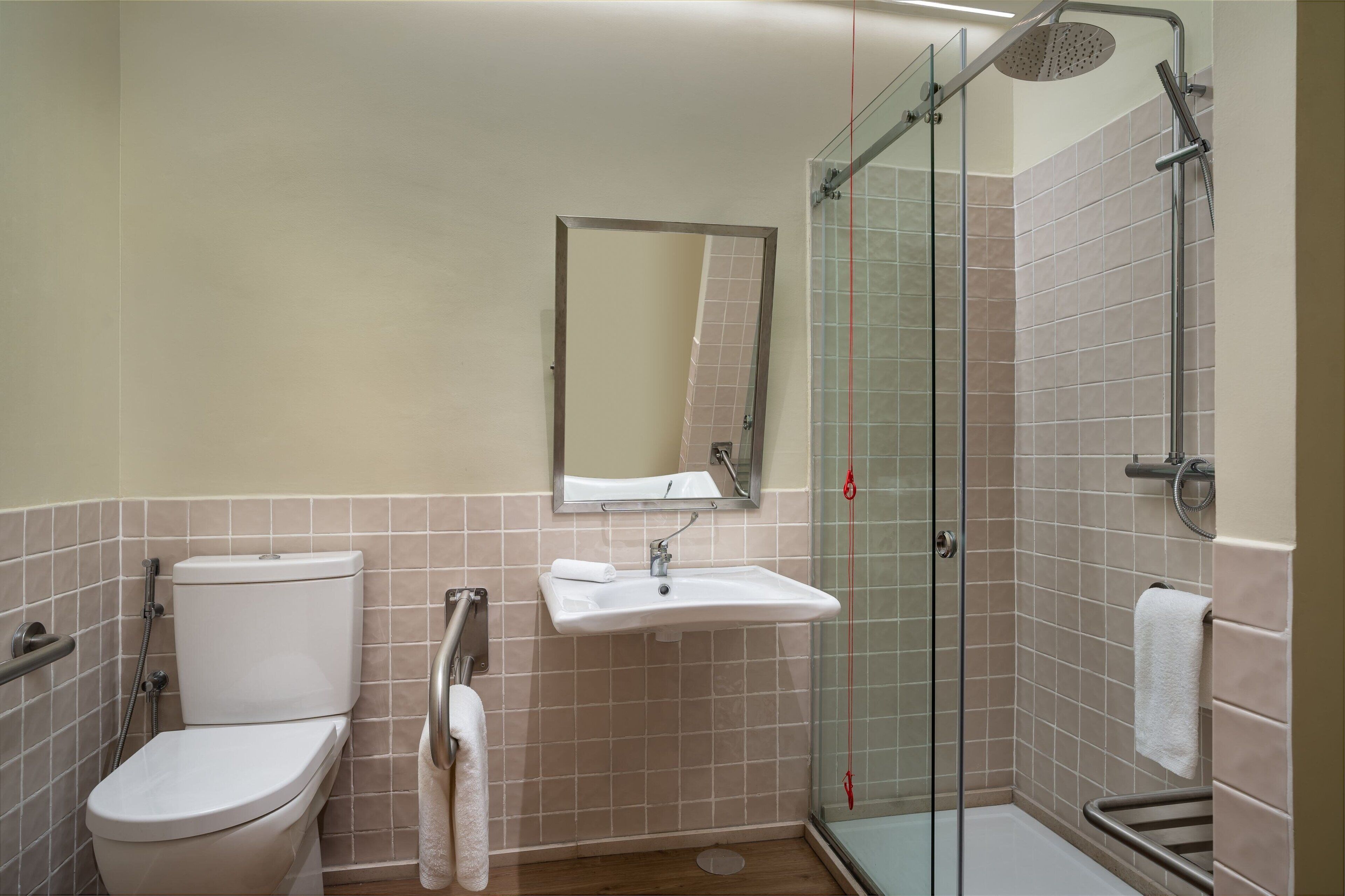 A bathroom with a toilet, sink, and glass-enclosed shower.