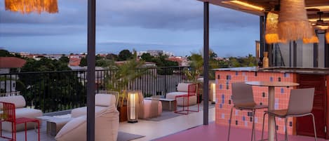 An outdoor patio with seating, a table, and hanging lights.