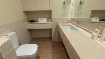 A compact bathroom with a toilet, sink, and mirror.