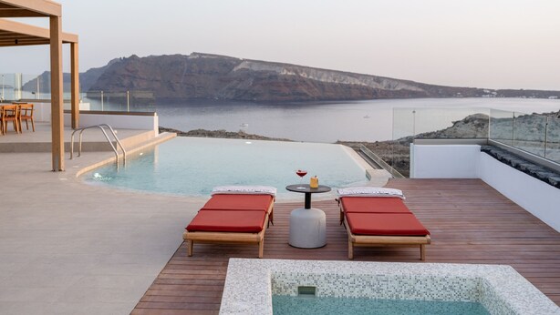 A rooftop infinity pool with two sun loungers and a small table, overlooking a cliff and the sea. - Scenic Pool Villa with Sunset & Sea View by Santo Collection, The Villas (Santorini)