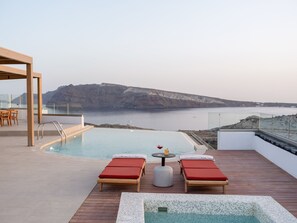 A rooftop infinity pool with two sun loungers and a small table, overlooking a cliff and the sea. - Scenic Pool Villa with Sunset & Sea View by Santo Collection, The Villas (Santorini)