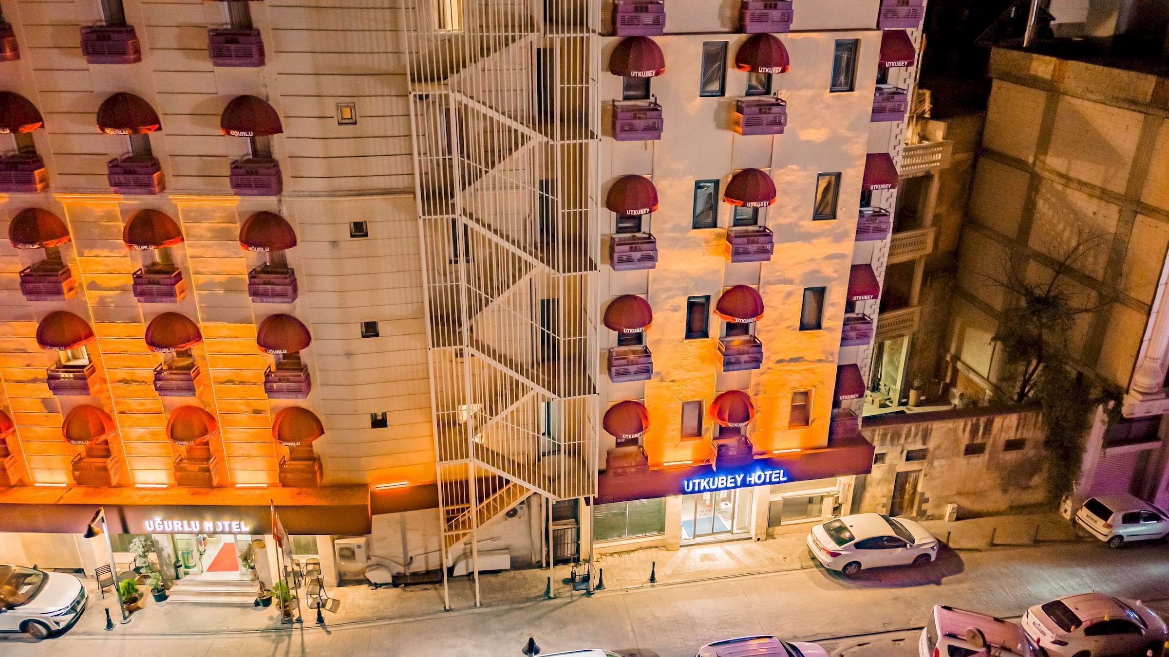 A hotel with multiple floors, a central staircase, and a prominent entrance with signage.