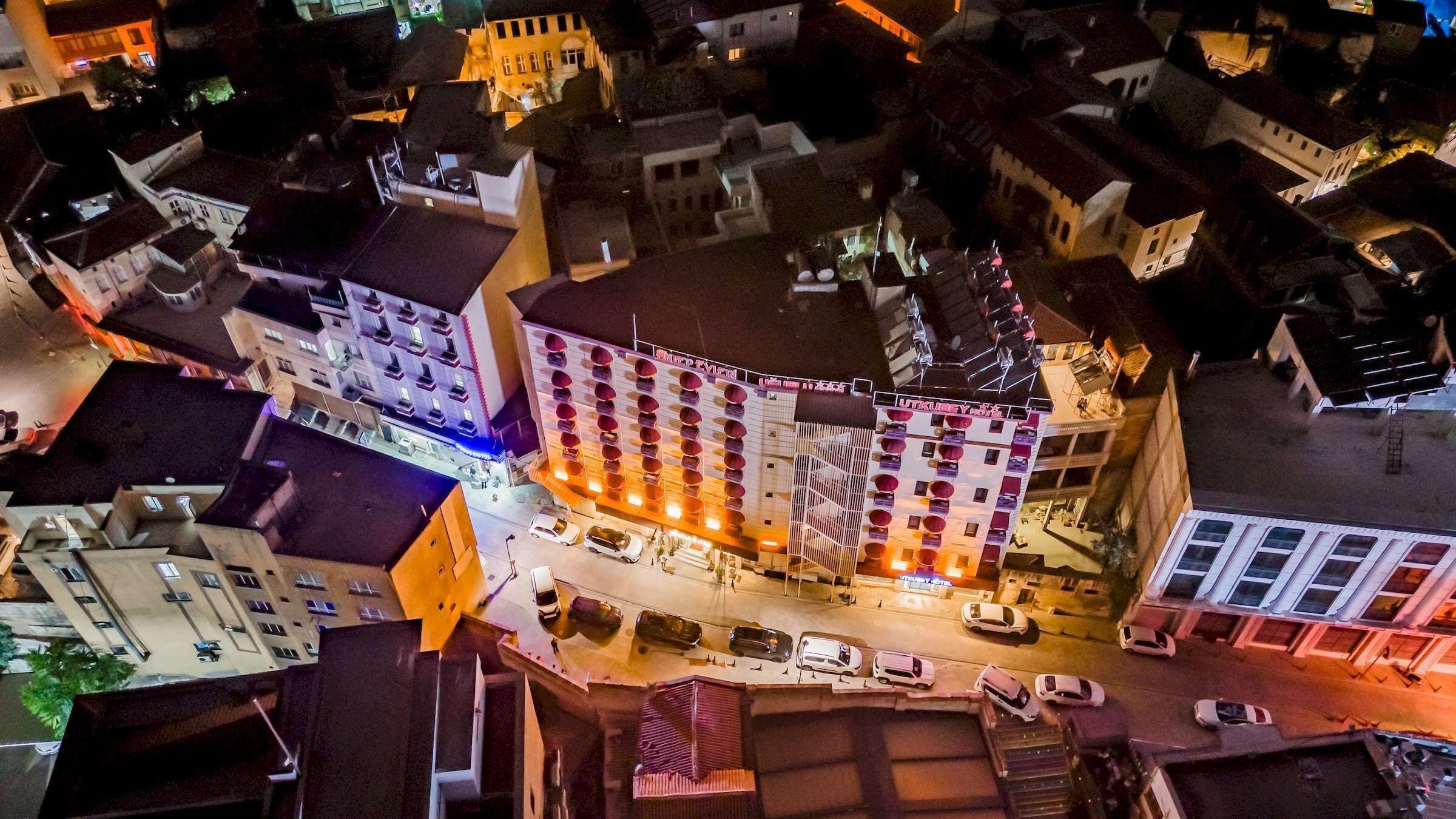 A multi-story hotel with a central courtyard, surrounded by other buildings.