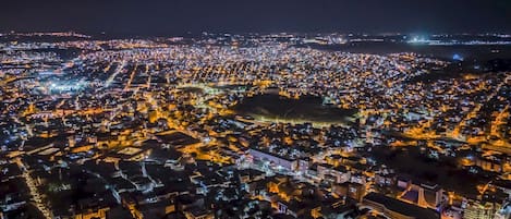 Une zone urbaine densément peuplée, illuminée la nuit par de nombreux bâtiments et rues.