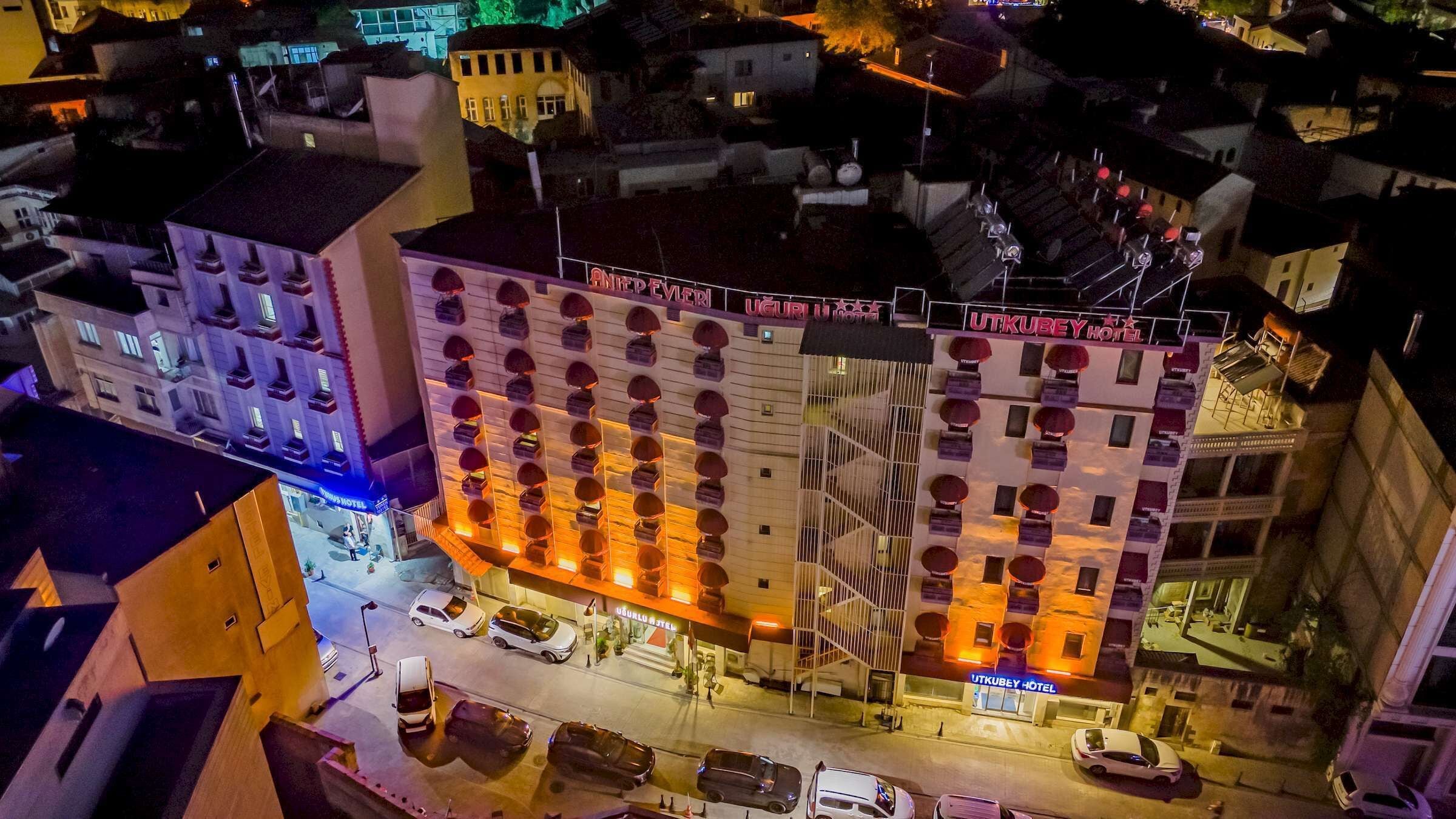 Um hotel com vários andares, átrio central, diversas varandas e estacionamento.