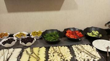 Buffet amb diversos aliments, com formatges, fruites i verdures.