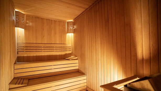 A wooden sauna with benches and a bench in the foreground. - Uğurlu Hotel (Gaziantep)