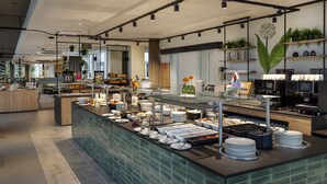 Un buffet moderne, avec une variété de plats et d’ustensiles, un coin café et des plantes décoratives.