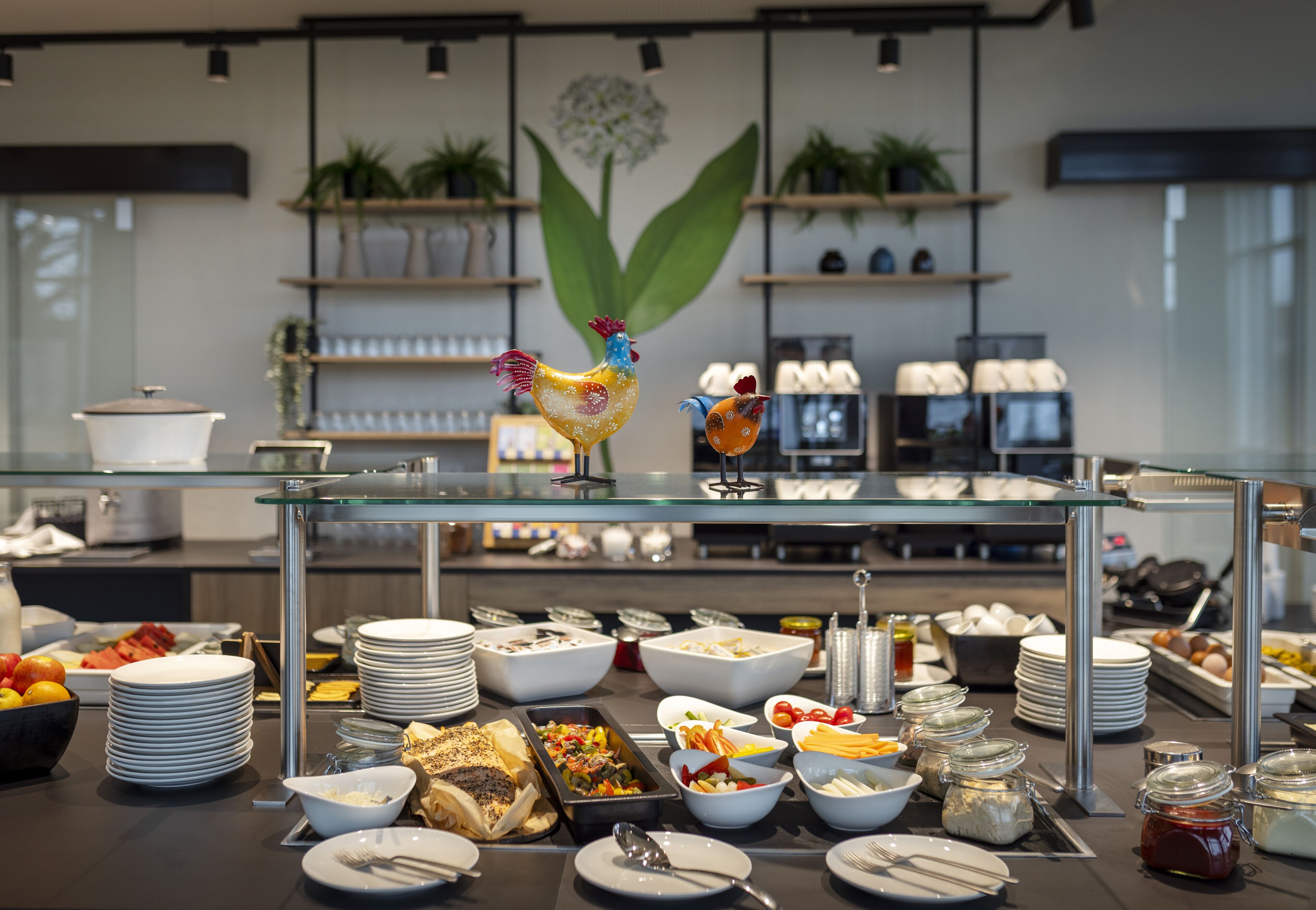 A buffet setup with various food items and a decorative rooster.