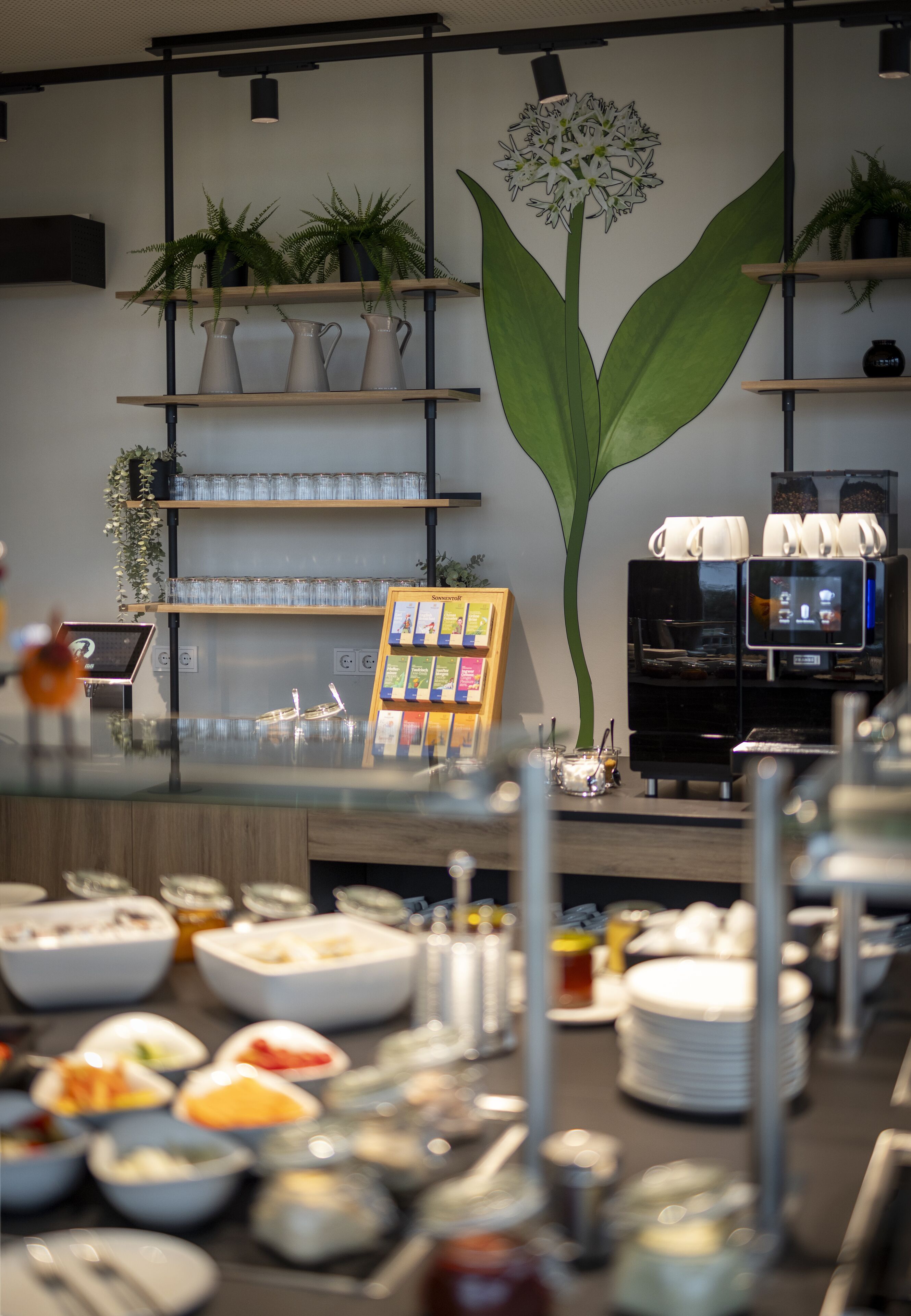 A buffet area with various food items and a coffee machine.