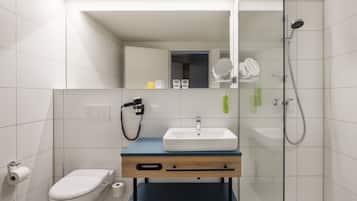 Ein modernes Badezimmer mit Toilette, Waschbecken und Dusche.