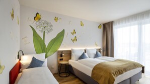 Une chambre d’hôtel avec deux lits, une table de chevet, une lampe et une grande fenêtre avec des rideaux.