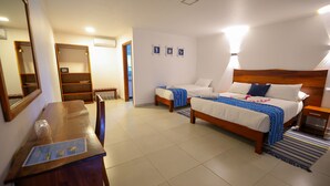 Habitació d'hotel amb un llit de fusta, escriptori, mirall i armari.