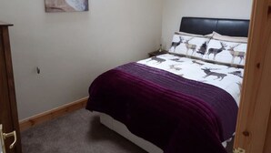 Una camera da letto con un letto, un comodino, una cassettiera e un’opera d’arte a tema animale.