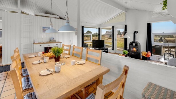 A spacious dining area with a wooden table and chairs, a television, and a fireplace. - "Josef" - 950m from the sea by Interhome (Fanø)