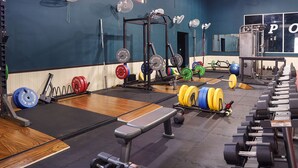 A gym with weightlifting equipment, a bench, and a mirror. - SANJEEVINI AYURVEDA AND YOGA RETREAT (Aluva)