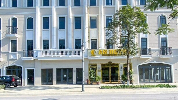 A large, classical building with a central entrance, multiple windows, and a symmetrical facade. - An Hotel Ha Long (Bai Chay)