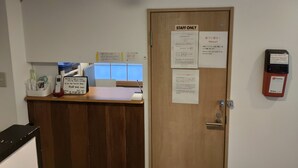 A reception area with a wooden desk, a phone, and a door labeled "STAFF ONLY". - Hotel Belle Via Tokyo (Tokyo)