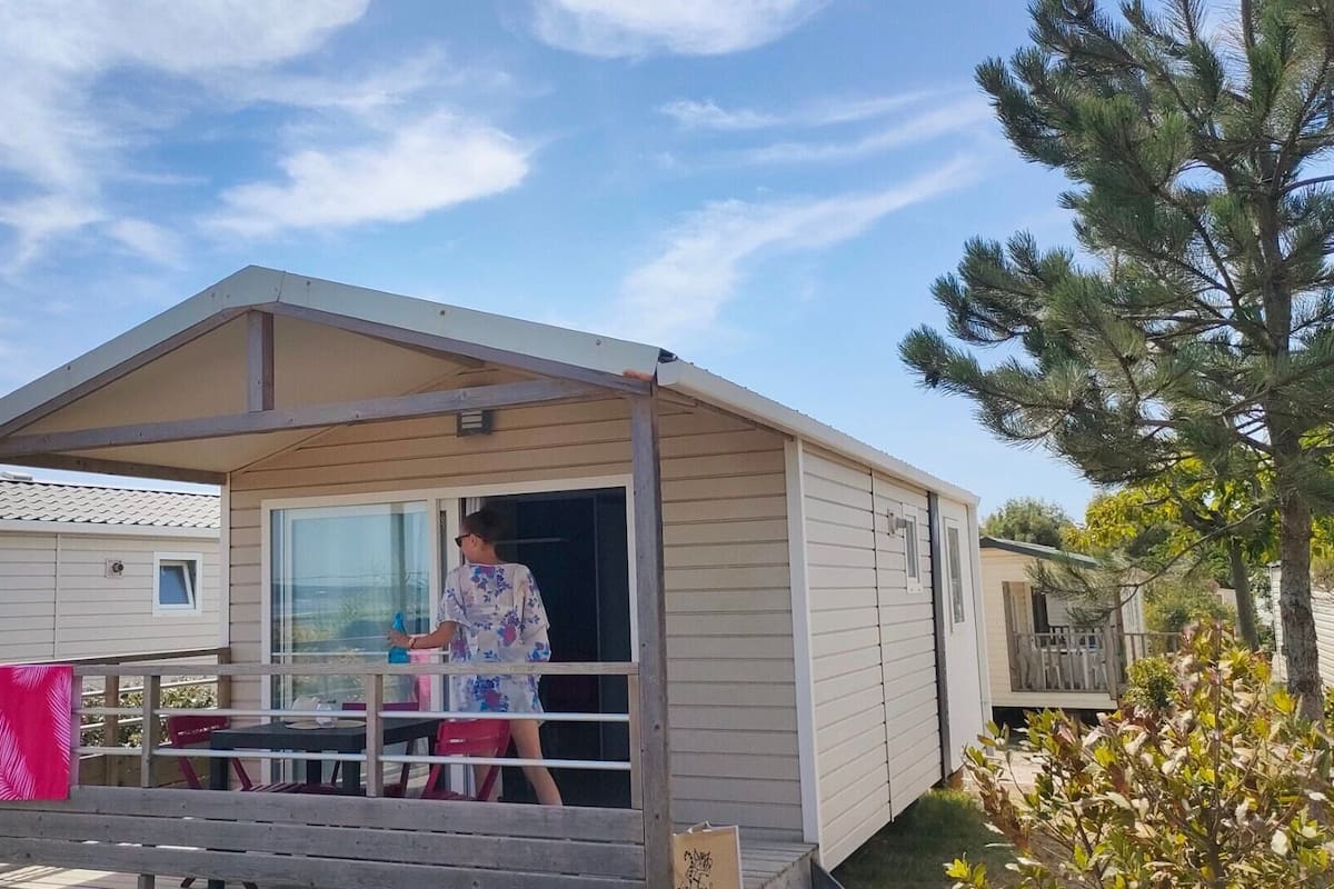 A single-story mobile home with a covered porch and a sliding glass door.