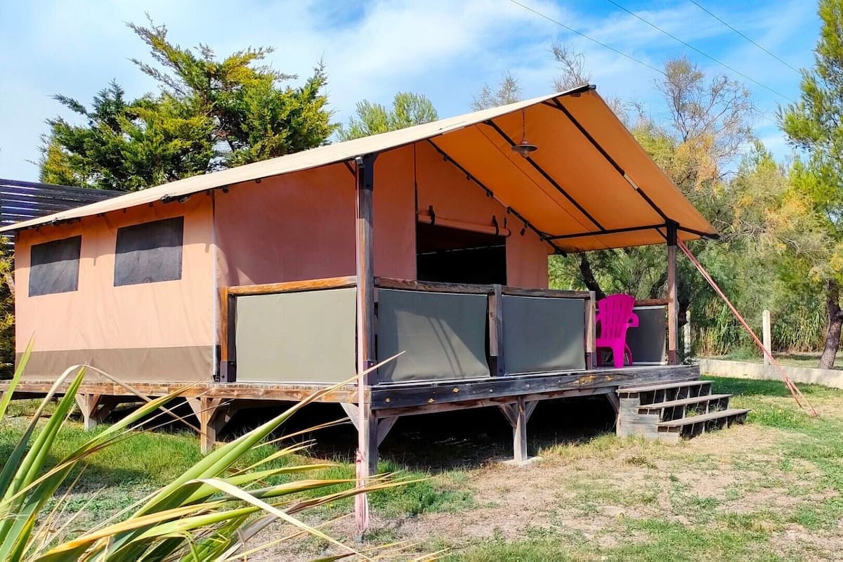 A small, single-story cabin with a porch and a covered seating area.