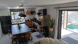 Une cuisine moderne dotée d’un îlot central, de tabourets de bar et d’un coin repas.
