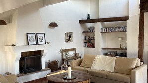 Una sala de estar con chimenea, un sofá, una mesa de centro y una estantería.