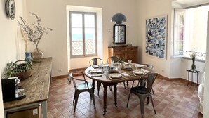 Un comedor con techo rústico, un ventanal con vistas y una mesa para cuatro comensales.