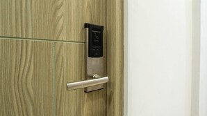 A wooden door with a card reader and a metallic handle.