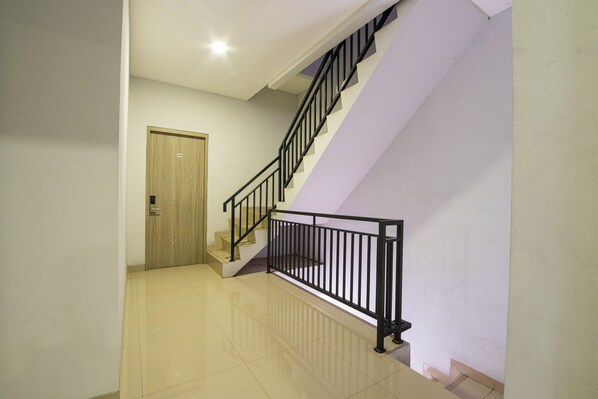Un escalier avec des rampes noires menant à l’étage supérieur.
