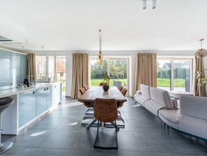 A modern kitchen with a dining area, large windows, and a view of the outdoors. - Overijse Grande Residence (Overijse)